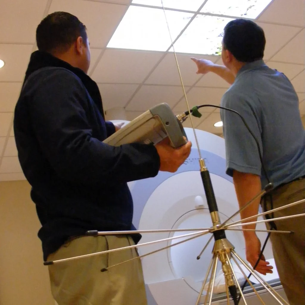 Engineers performing electromagnetic shielding maintenance on MRI room